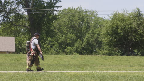 Bomberos-Caminando-Por-La-Acera-Después-De-La-Evolución-Del-Ejercicio-Con-Fuego-Vivo-En-La-Estación-De-Bomberos-De-Siloam-Springs-En-Arkansas,-EE.UU.