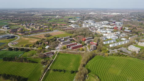 Warwick-University-campus-and-sports-fields-in-Coventry-with-city-skyline-in-background,-high-Ariel-view