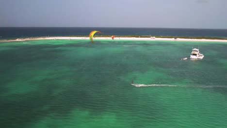 Kiteboarders-ride-the-waves-near-Crasky-in-Los-Roques,-aerial-view