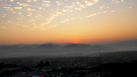 Aerial-view-gentle-mist-covers-the-landscape-at-sunset-in-Pai,-Thailand