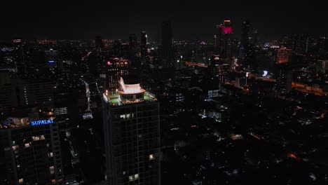 Aerial-View-Of-Buildings-Illuminated-At-Night-In-Bangkok,-Thailand---Drone-Shot