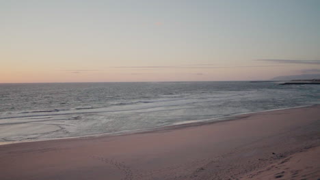 Playa-Tranquila-Al-Atardecer-Con-Suaves-Olas-Y-Un-Cielo-Pastel