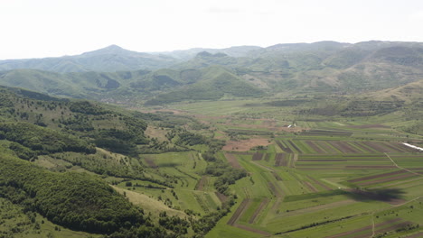 Slow-aerial-panning-view-over-fertile-valley-farmland-near-Piatra-Secuiului,-villages-of-Rimetea-and-Coltesti,-Romania