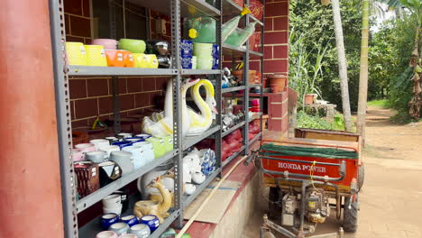 Close-up-handheld-shot-of-mud-crafts-displayed-on-shelf-in-front-of-country-store