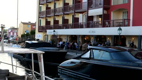 Luxury-yachts-in-front-of-dining-tourist-at-port-Grimaud,-France