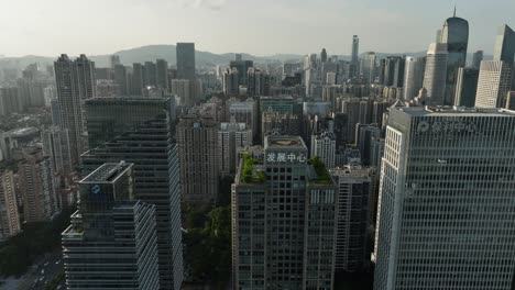 Tianhe-District-above-Huaxia-Road,-Guangzhou-financial-district-on-golden-hour,-drone-footage