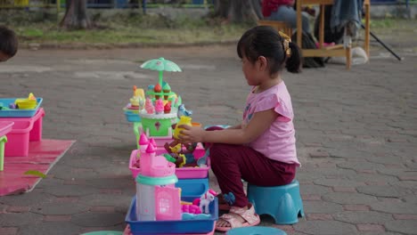 Kleines-Mädchen-Spielt-Mit-Bunten-Spielsachen-Im-Freien-Bei-Alun-Alun-Ahmad-Yani-Tangerang