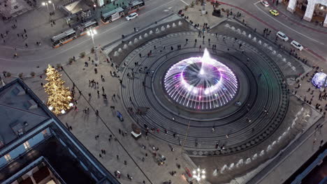 Los-Turistas-Visitan-La-Famosa-Fuente-De-Bronce-De-La-Piazza-De-Ferrari-En-Génova,-Drone-Nocturno.