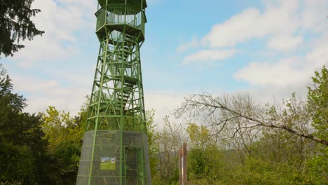 Lookout-tower-in-Cheddar,-England,-surrounded-by-trees-under-a-bright-blue-sky