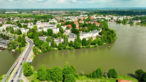 Vista-Aérea-De-Iława-Con-El-Lago-Jeziorak,-Que-Muestra-Una-Pintoresca-Ciudad-Rodeada-De-Exuberante-Vegetación,-Propiedades-Frente-Al-Mar-Y-Un-Paisaje-Pintoresco.