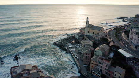 Golden-hour-aerial-over-Boccadasse-beach-in-Genoa-on-Liguria-coastline,-Italy