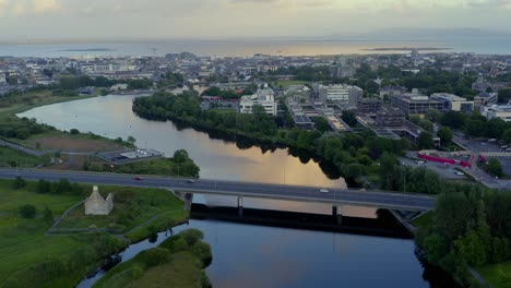 Antenne-Mit-Überblick-über-Galway-Vom-Fluss-Corrib-Bei-Sonnenuntergang-Mit-Mutton-Island-In-Der-Ferne