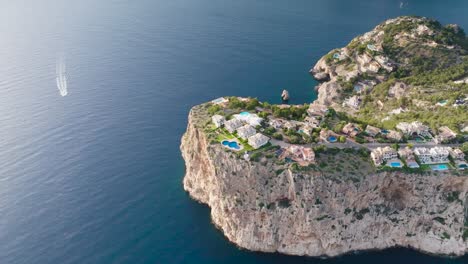 Scenic-aerial-view-of-rugged-limestone-cliff-near-turquoise-water-lagoon