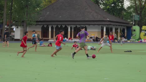 Kids-playing-soccer-on-a-green-field-at-Alun-Alun-Ahmad-Yani-Tangerang-during-the-day