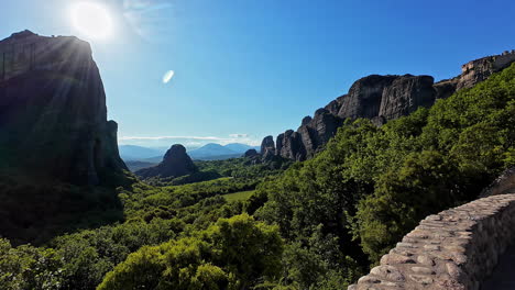 Impresionante-Vista-De-Las-Formaciones-Rocosas-De-Meteora-Y-La-Exuberante-Vegetación-Bajo-Un-Cielo-Azul-Claro.