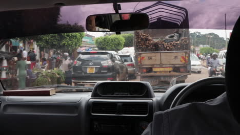 Coche-Conduciendo-Por-Una-Calle-Muy-Transitada-Con-Mercado-En-Kampala-En-Uganda,-África