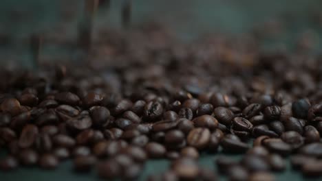 Close-up-coffee-beans-falling,-spilling-onto-the-dark-table