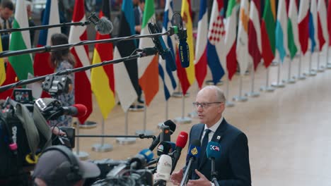 El-Primer-Ministro-De-Luxemburgo,-Luc-Frieden,-Hablando-Con-La-Prensa-En-La-Cumbre-Del-Consejo-Europeo-En-Bruselas,-Bélgica:-Cámara-Lenta,-Plano-Medio.