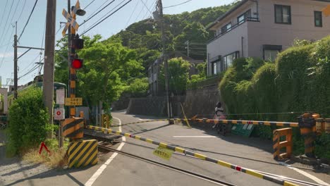 Famous-Enoshima-Dentetsu-train-passing-through-residential-areas-in-Kamakura,-Japan