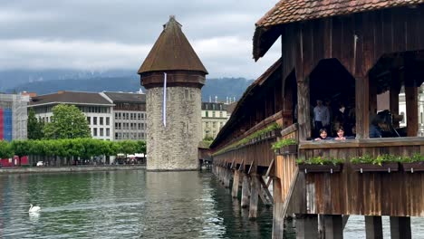 Two-children-on-old-wooden-Chapel-Bridge-of-Lucerne-City-during-cloudy-day-in-Switzerland