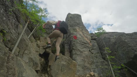 Two-hikers-climb-steep-rocky-terrain-on-Litlefjellet-Hike-in-Norway-under-a-partly-cloudy-sky