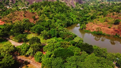 Atemberaubende-Luftaufnahme-Einer-Wunderschönen-Afrikanischen-Landschaft-Mit-Grünen-Bäumen-In-Einem-Park-Entlang-Eines-Flusses-In-Abuja,-Nigeria