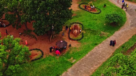 Vista-De-ángulo-Alto-De-Familias-Vestidas-Con-Ropa-Tradicional-Africana-Jugando-En-Un-Parque-En-Un-Día-Soleado-En-Abuja,-Nigeria