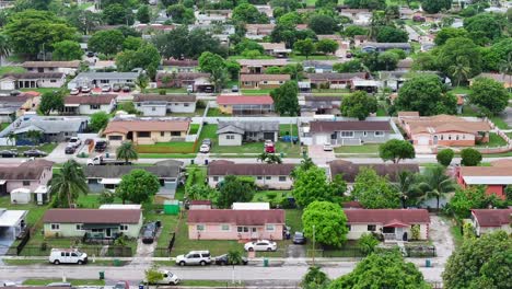 Aerial-view-of-a-suburban-neighborhood-during-the-day,-featuring-rows-of-single-story-houses,-green-lawns,-and-tree-lined-streets