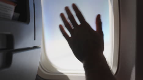 waving-goodbye-from-inside-an-airplane-through-the-plane's-window