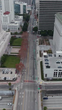 Los-Angeles-CA-USA,-Vertical-Aerial-View-of-City-Hall,-US-Courthouse,-Hall-of-Justice-and-Downtown-Skyscrapers,-Revealing-Drone-Shot-by-US-101-Interstate-Route-Highway