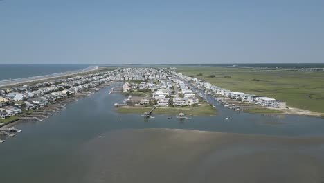 4k-rotating-drone-shot-of-the-marsh-behind-Sunset-Beach,-NC-including-the-bridge-and-Intracoastal-Waterway