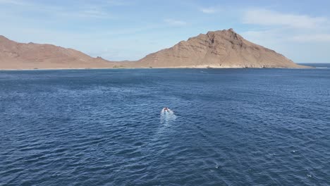 Vista-Aérea-Del-Barco-Navegando-Frente-A-Una-Isla-Deshabitada