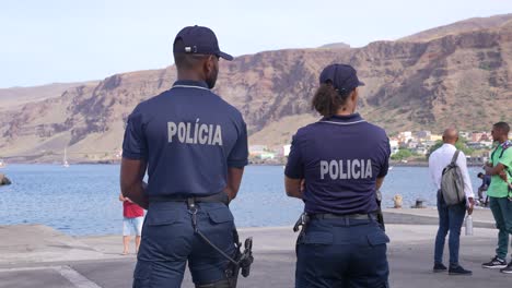 Couple-of-Local-Police-Officers,-Man-and-Woman,-in-Tarrafal-Port,-Cape-Verde,-Back-View