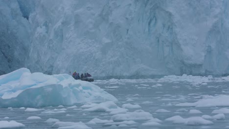 Touristenboot,-Das-An-Einem-Verschneiten-Tag-Unter-Einem-Gletscher-Zwischen-Eis-Und-Eisbergen-Im-Kalten-Meerwasser-Segelt