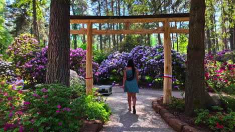 Frau-Spaziert-Durch-Malerischen-Park-Mit-Schönen-Blumen-–-Kamerafahrt