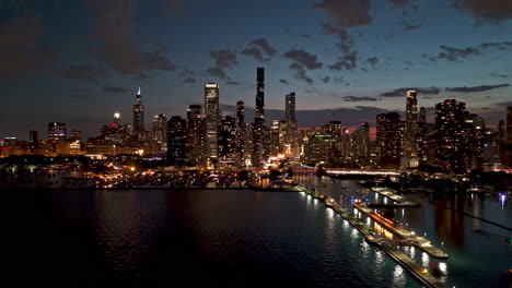 AERIAL:-Dusk-sky-with-small-clouds-above-the-illuminated-skyscrapers-of-Chicago