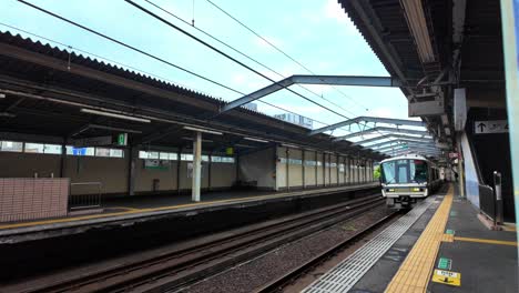 Ein-Jr.-West-Zug-Nach-Namba-Fährt-In-Den-Bahnhof-Inamiya-In-Osaka,-Japan-Ein,-Um-Pendler-Aus-Nara-Entlang-Der-Osaka-Loop--Und-Namba-Linien-Zu-Befördern