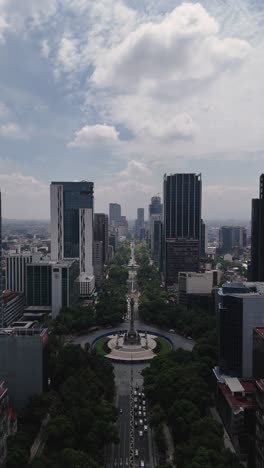 Paseo-de-la-Reforma-with-its-buildings-and-the-Angel-of-Independence-in-the-middle,-vertical-aerial-view