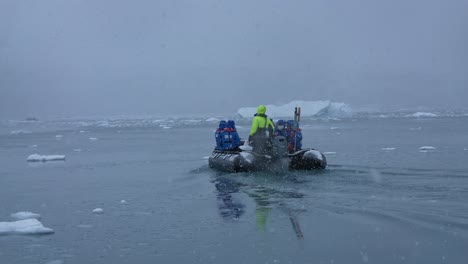 Turistas-En-Barco-Navegando-Por-La-Costa-De-La-Antártida-En-Un-Día-Nevado,-Cámara-Lenta