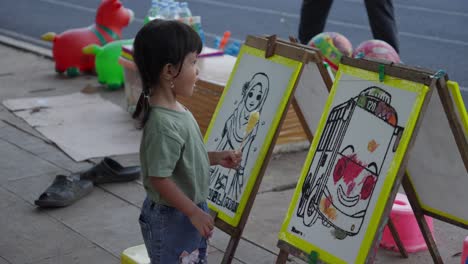 Un-Niño-Observa-Dibujos-Coloridos-En-Una-Exhibición-De-Arte-Al-Aire-Libre-En-Alun-Alun-Ahmad-Yani-Tangerang