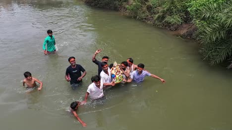 Escena-De-Aldeanos-Sumergiendo-Un-ídolo-De-Ganesha-En-El-Río