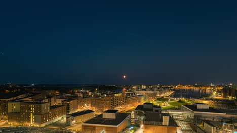 Evening-to-night-timelapse-of-the-moon-moving-over-the-cityscape-of-Helsinki