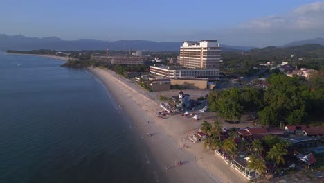 Küste-Von-Langkawi-Mit-Hotels-Und-Resorts-An-Einem-Tropischen-Strand-Und-Touristen,-Die-Das-Klare-Blaue-Wasser-Genießen