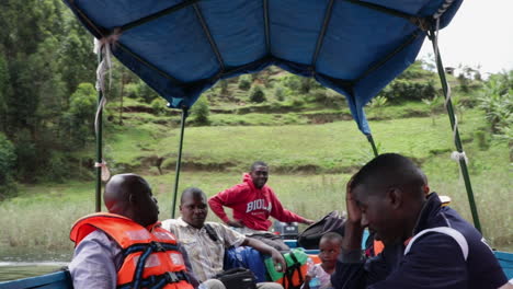 A-Group-Of-Men-And-Boy-Sitting-On-A-Boat-And-Talking-In-Uganda,-Africa