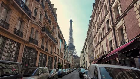 Vista-En-Primera-Persona-De-Una-Típica-Calle-Parisina-Y-Sus-Antiguos-Edificios-De-Arquitectura-Francesa-Con-La-Icónica-Torre-Eiffel-En-El-Horizonte---París,-Francia