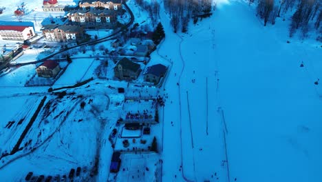 Eine-Luftaufnahme-Eines-Schneebedeckten-Dorfes-In-Den-Bergen,-Das-Die-Schönheit-Des-Winters-Einfängt