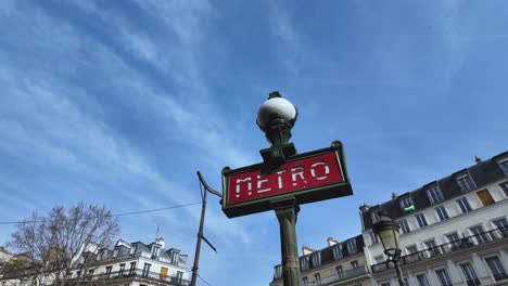 slow-motion-video-of-a-classic-Parisian-metro-sign-in-a-sunlight-blue-sky-day---Paris,-France