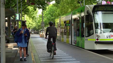 Trams-arrived-at-the-stop-on-Swanston-street,-with-passengers-disembarking-and-boarding-the-tram-during-rush-hour-in-Melbourne's-Central-Business-District,-city-center-with-influx-in-population