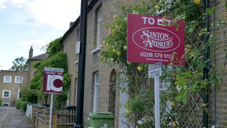 Two-estate-agents-signs-outside-residential-houses-in-Ealing-London-United-Kingdom-June-2024