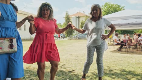 Tres-Damas-Sonrientes-En-El-Festival-Folclórico-Búlgaro-Bailan-Horo-Tradicional